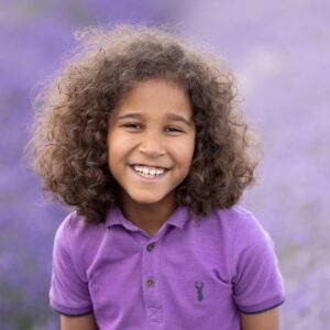 A boy smiles at the camera during a photoshoot at Hitchin Lavender fields